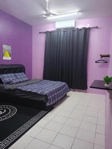 um quarto com cortinas roxas e pretas e uma cama em Aras G Homestay em Gambang