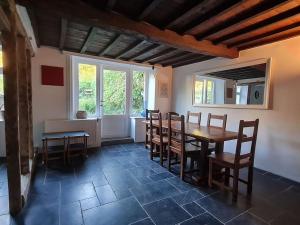 a dining room with a wooden table and chairs at La maison d'à côté in Tellin