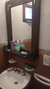 W łazience znajduje się umywalka i lustro. w obiekcie Hostal Tía Dora w mieście San Salvador de Jujuy