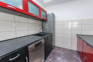 a kitchen with a sink and red cabinets at Apartments Mladen in Duće +71 photos