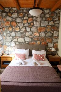 1 dormitorio con 1 cama y pared de piedra en Mike Omalos Houses en Omalós