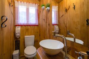 La salle de bains en bois est pourvue de toilettes et d'un lavabo. dans l'établissement Pousada Fazenda Rio das Pedras, à Visconde de Mauá