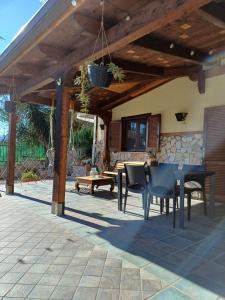 een patio met een tafel en stoelen onder een houten pergola bij La Tana di Otto in Montalto Uffugo