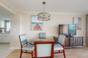 a dining room with a table and chairs and a chandelier at Marco Beach Ocean Resort 801 in Marco Island