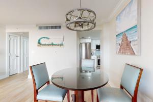 a dining room with a glass table and chairs at Marco Beach Ocean Resort 801 in Marco Island