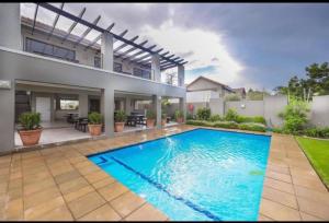 a large swimming pool in the backyard of a house at Captivating 2-Bed Apartment in Sandton in Sandton