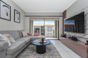 a living room with a couch and a tv at Captivating 2-Bed Apartment in Sandton in Sandton