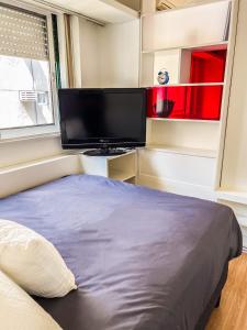 1 dormitorio con 1 cama y TV de pantalla plana en RentUp - Ubicacion privilegiada, junto a los Bosques de Palermo en Buenos Aires