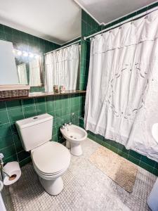 a green tiled bathroom with a toilet and a sink at RentUp - Ubicacion privilegiada, junto a los Bosques de Palermo in Buenos Aires
