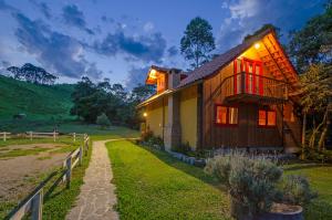 una casa con ventanas rojas en el lateral. en Pousada Fazenda Rio das Pedras, en Visconde De Maua