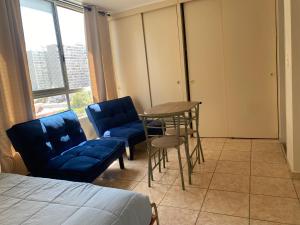 um quarto com uma cama, uma mesa e cadeiras em Apartamento completo amoblado Santiago cercano Movistar Arenas em Santiago