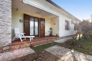 eine Veranda eines Hauses mit einem weißen Stuhl darauf in der Unterkunft Casa tra gli ulivi vicino al mare in Seravezza