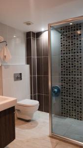 a bathroom with a toilet and a glass shower at Truva Life Hotel in Samandağı