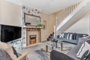 a living room with a fireplace and a tv at Ashby House in Coalville