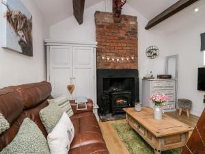 a living room with a couch and a fireplace at High Wreah Bolt Hole in Whitehaven