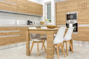 een keuken met een houten tafel en witte stoelen bij Modern fully Equipped 1BR home in St Julians by 360 Estates in St Julian's