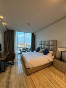 Pokój hotelowy z łóżkiem, biurkiem i stołem w obiekcie 4Leisure Suites DAMAC Esclusiva Towers w Rijadzie