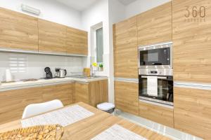 een keuken met houten kasten en een fornuis met oven bij Modern fully Equipped 1BR home in St Julians by 360 Estates in St Julian's