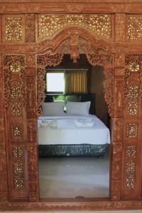 a bedroom with a bed with a wooden frame at Lamina Repoq Hiils in Kuta Lombok