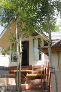 una casa con dos árboles delante de ella en Lamina Repoq Hiils, en Kuta Lombok