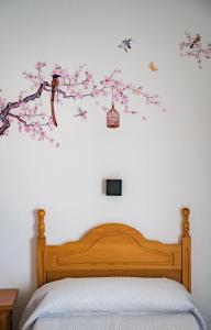 巴薩的住宿－HOSTAL CACHE，一间卧室,床上有一棵树,上面有鸟儿