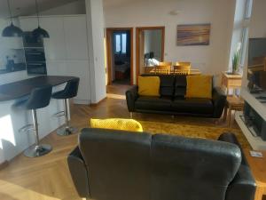 a living room with a black couch and yellow pillows at Remarkable 2-Bed Apartment near Bognor beaches in Bognor Regis