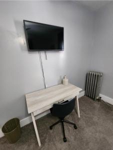 a desk with a television on a wall with a chair at DCU Center, Woo-Sox Stadium, Kelly square in Worcester