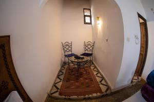 uma pequena mesa e duas cadeiras num corredor em Dar Arinas Fez em Fez