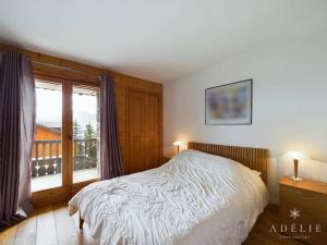 a bedroom with a bed and a large window at Charmant 3 pièces au centre station avec balcon, parking et WiFi gratuit - FR-1-398-579 in Montvalezan