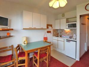 a kitchen with a table and chairs and a kitchen with white cabinets at Studio Montvalezan-La Rosière, 1 pièce, 4 personnes - FR-1-398-574 in La Rosière