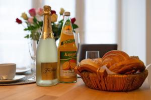 Una mesa con dos botellas de champán y una cesta de pan. en Schwarzwaldnestle, en Bad Wildbad