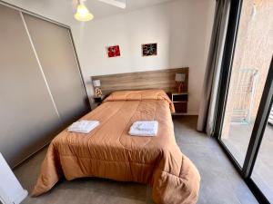 a bedroom with a bed with two towels on it at Lumier Apartment 1- Moderno departamento en planta baja, cochera privada in El Challao