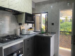 uma cozinha com um fogão, um lavatório e uma janela em MAJESTIC VILLA RESIDENCE em Ankuru