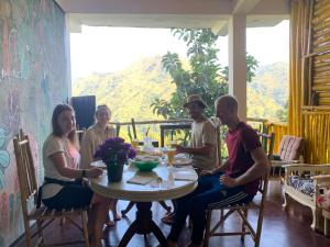 un gruppo di persone seduti intorno a un tavolo di Paradise view hostel a Ella