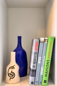 a shelf with a blue vase and books on it at Jad - Luxe - piscine - 6 Px in Agadir