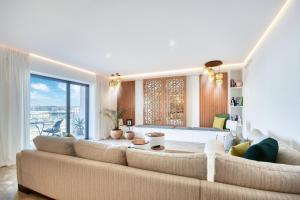 a living room with a large couch and a large window at Jad - Luxe - piscine - 6 Px in Agadir
