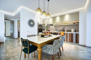 a kitchen and dining room with a wooden table and chairs at Jad - Luxe - piscine - 6 Px in Agadir