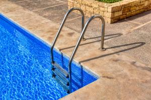 a blue swimming pool with a metal railing next to it at Jad - Luxe - piscine - 6 Px in Agadir