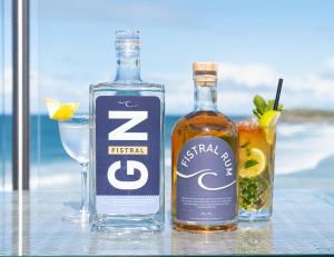 two bottles of alcohol and two glasses on a table at Fistral Beach Hotel and Spa - Adults Only in Newquay