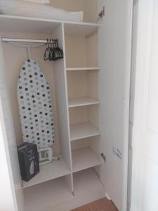 a white cupboard with shelves in a room at Tollgate Drive in Southall