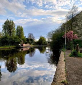 a river with reflections of clouds in the water at Tollgate Drive in Southall