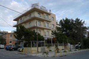 ein hohes Gebäude mit Balkon darüber in der Unterkunft IKAROS Hotel ELLINIKO in Athen