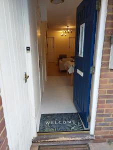 a blue door with a welcome sign in a hallway at Tollgate Drive in Southall
