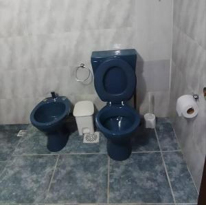 a bathroom with a blue toilet and a bidet at María Chusena alojamiento 3 in Fray Bentos