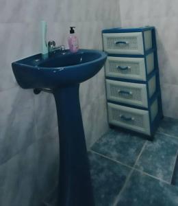 uma casa de banho com um lavatório azul e uma cómoda em María Chusena alojamiento 3 em Fray Bentos