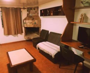 uma sala de estar com um sofá e uma lareira em María Chusena alojamiento 3 em Fray Bentos