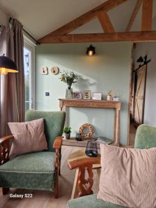 een woonkamer met 2 stoelen en een tafel bij Huys de Landerije in Wouwsche Plantage