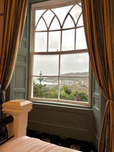 a bedroom with a window with a view at Ivybank Villa in Rothesay