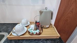 a wooden tray with a coffee maker on a table at St Albans Stylish Suite with kitchenette in London Colney
