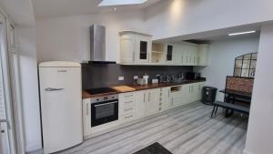 a kitchen with white cabinets and a refrigerator at St Albans Stylish Suite with kitchenette in London Colney